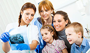 Mother and Children Viewing X-Rays with Dental Technician